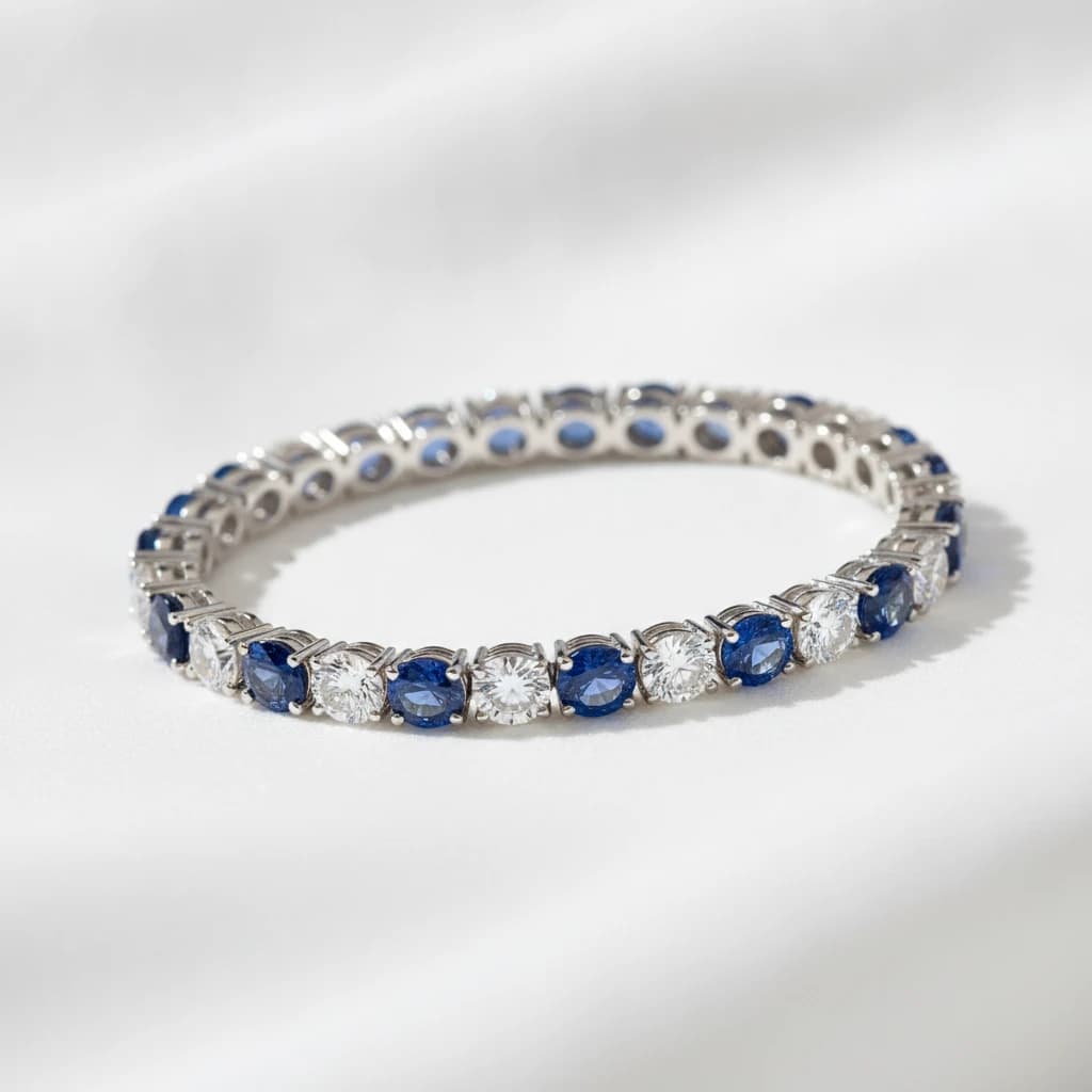 Tennis bracelet featuring alternating round diamonds and blue sapphires set in platinum