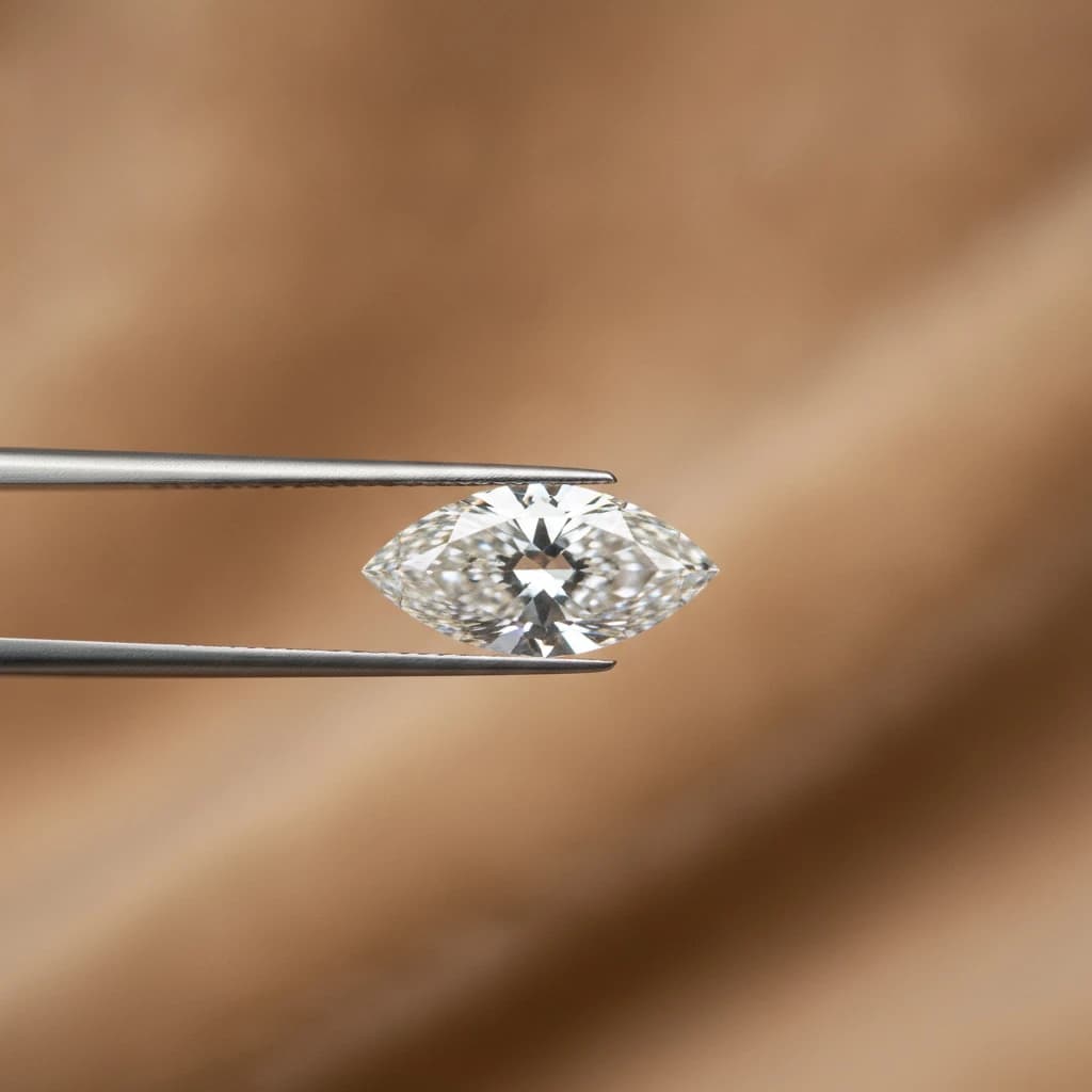 Loose marquise cut diamond held with tweezers over a soft beige surface