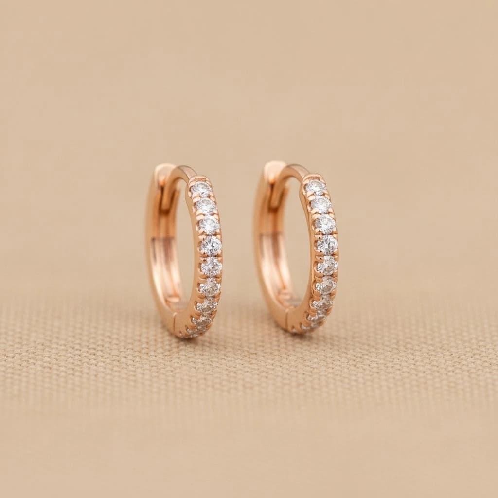 Pair of small diamond-paved huggie hoop earrings in 14k rose gold
